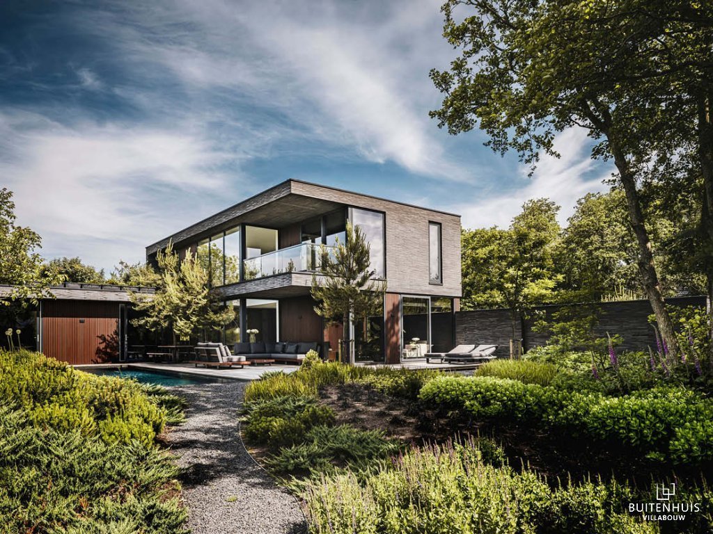 ThumbnailFotografie van een Buitenhuis Villabouw project, een modern huis met grijze houten gevel, zwembad, en houten terras.