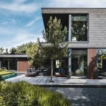 ThumbnailFoto van een luxe kubistische villa met een zwembad en houten terras, die het architectonisch ontwerp en de buitenruimte laat zien.