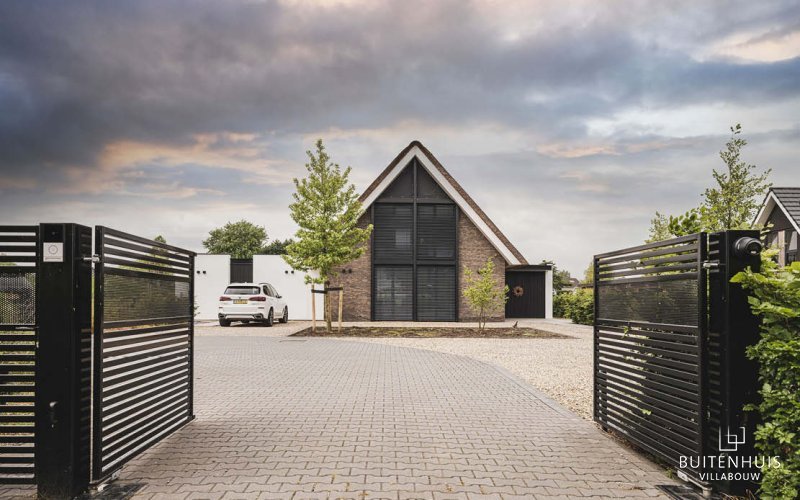Modern landhuis met rieten kap en strakke tuin